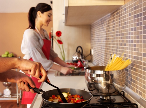 Multiple cooks in a well designed and remodeled kitchen with glass backsplash.