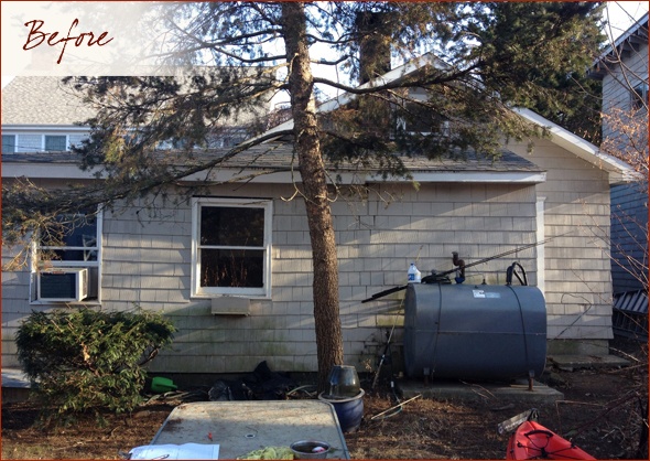 View of the cottage from the side, showing the propane tank