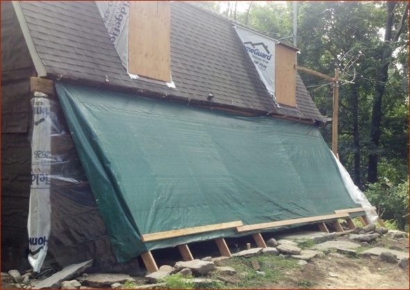 Historic house is tarped to protect it from weather and animals.