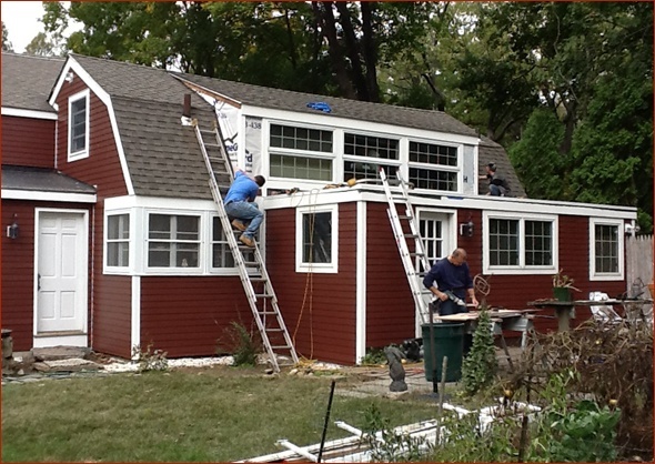 Tradespeople put the finishing touches on the Hardiplank siding and exterior trim.