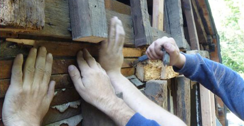 Workers remove the rotted beams and studs on this antique New England home.
