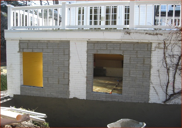 Masonry wall framed with concrete block with a brick pattern.