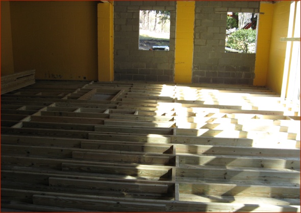 Framed basement floor with joists over concrete.