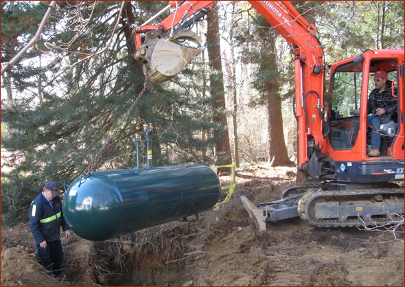 Propane tank is lowered into place.