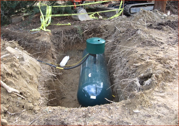Propane tank in place in large hole.