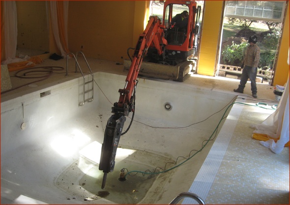 Dirt is exposed as pool bottom is broken up.