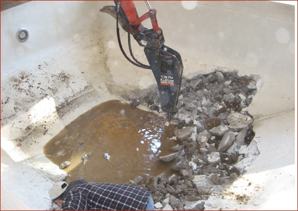Dirt is exposed as pool bottom is broken up.