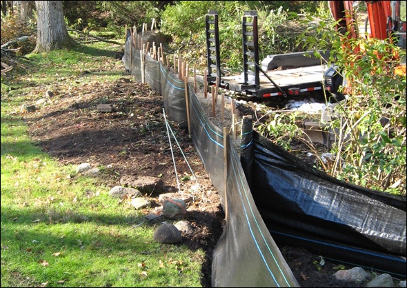 Silt fence and hay bales protect the wetlands from the construction project