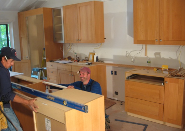 Carpenters install traditional cabinets to the kitchen designs