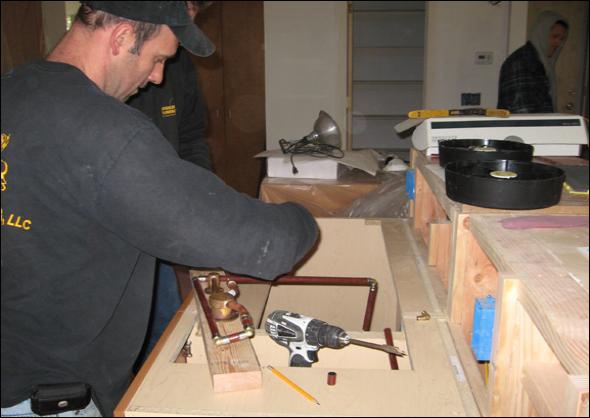 Plumber installs the wall mounted faucet.
