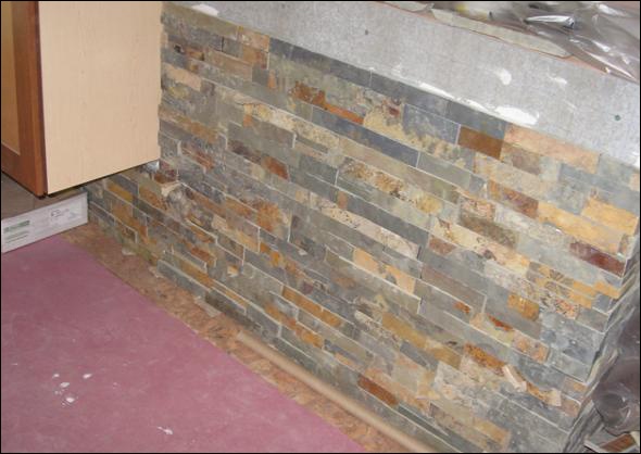 stone at the back of the island is practical as well as beautiful