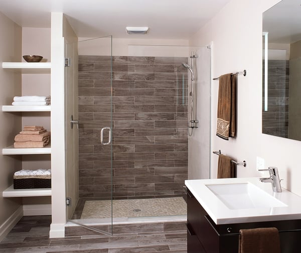 Gorgeous updated guest bath in renovated basement with full tile shower and glass doors.