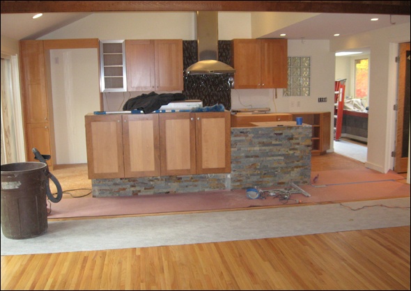Two tone cabinets hold china at the back of the island.