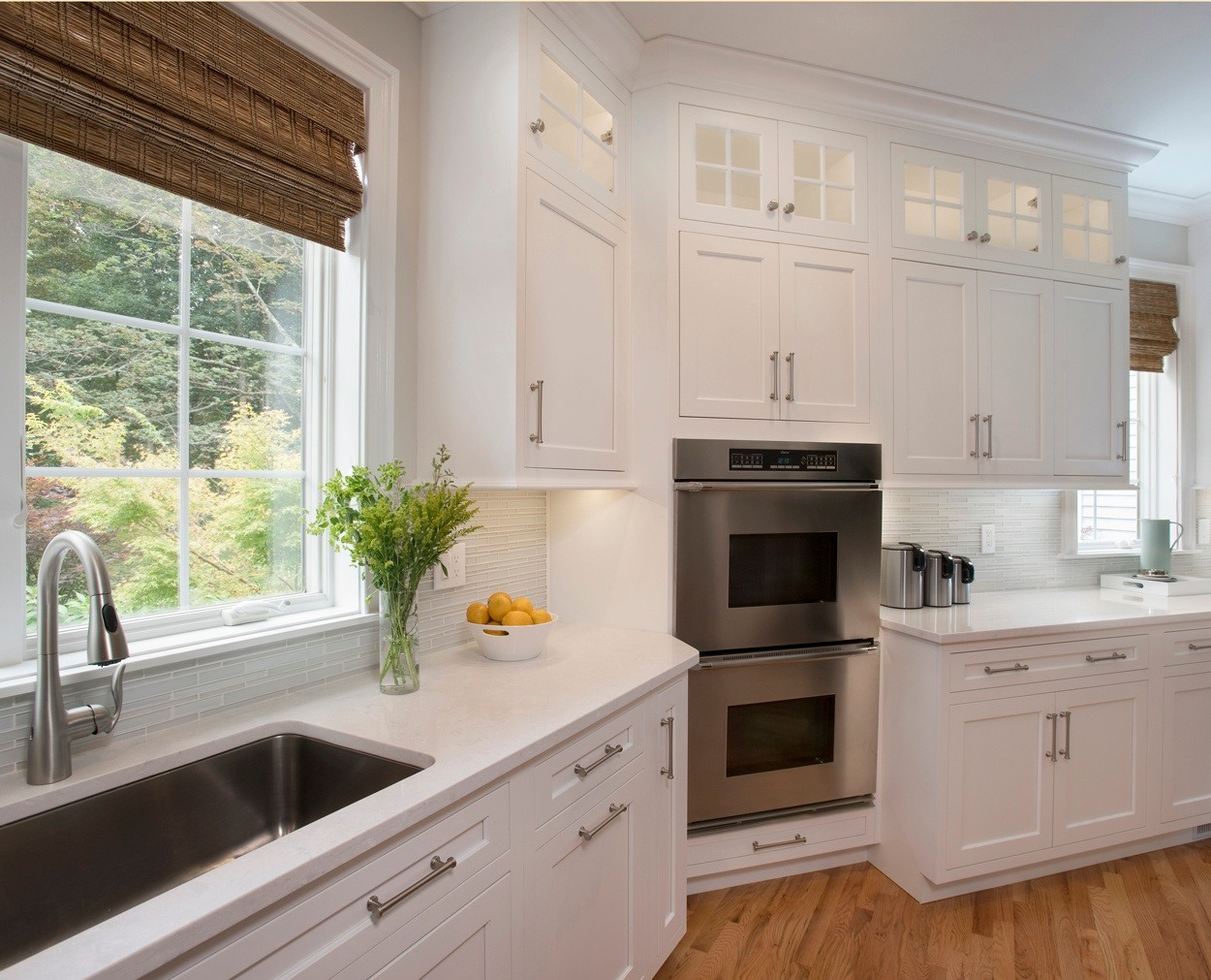 Corner cabinet houses double oven, with large sink under window.