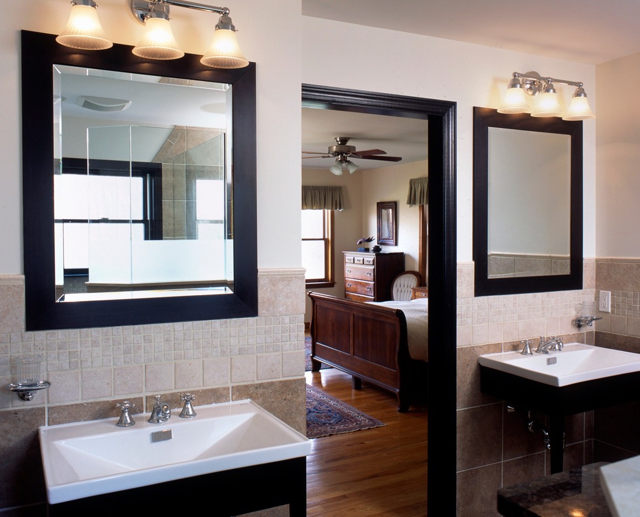 Dark framed mirrors and matching vanities in remodeled master bedroom suite.