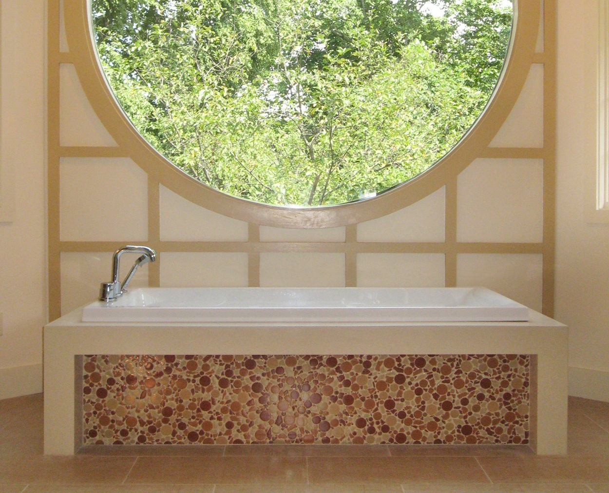 Tub deck looks like on piece of stone, with round glass tile