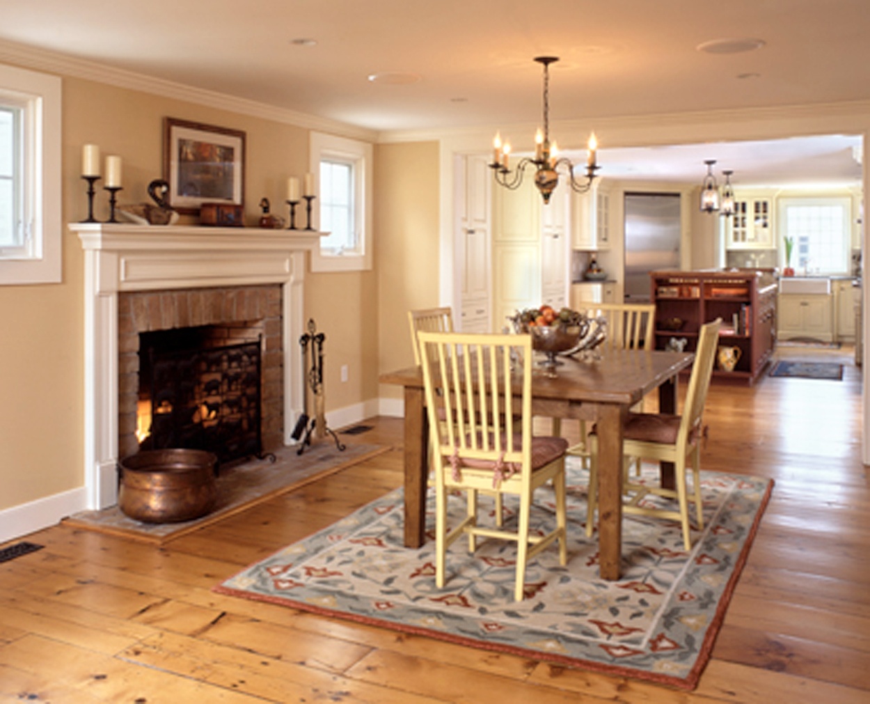 Dining table to the right of the fireplace in this traditional colonial home.