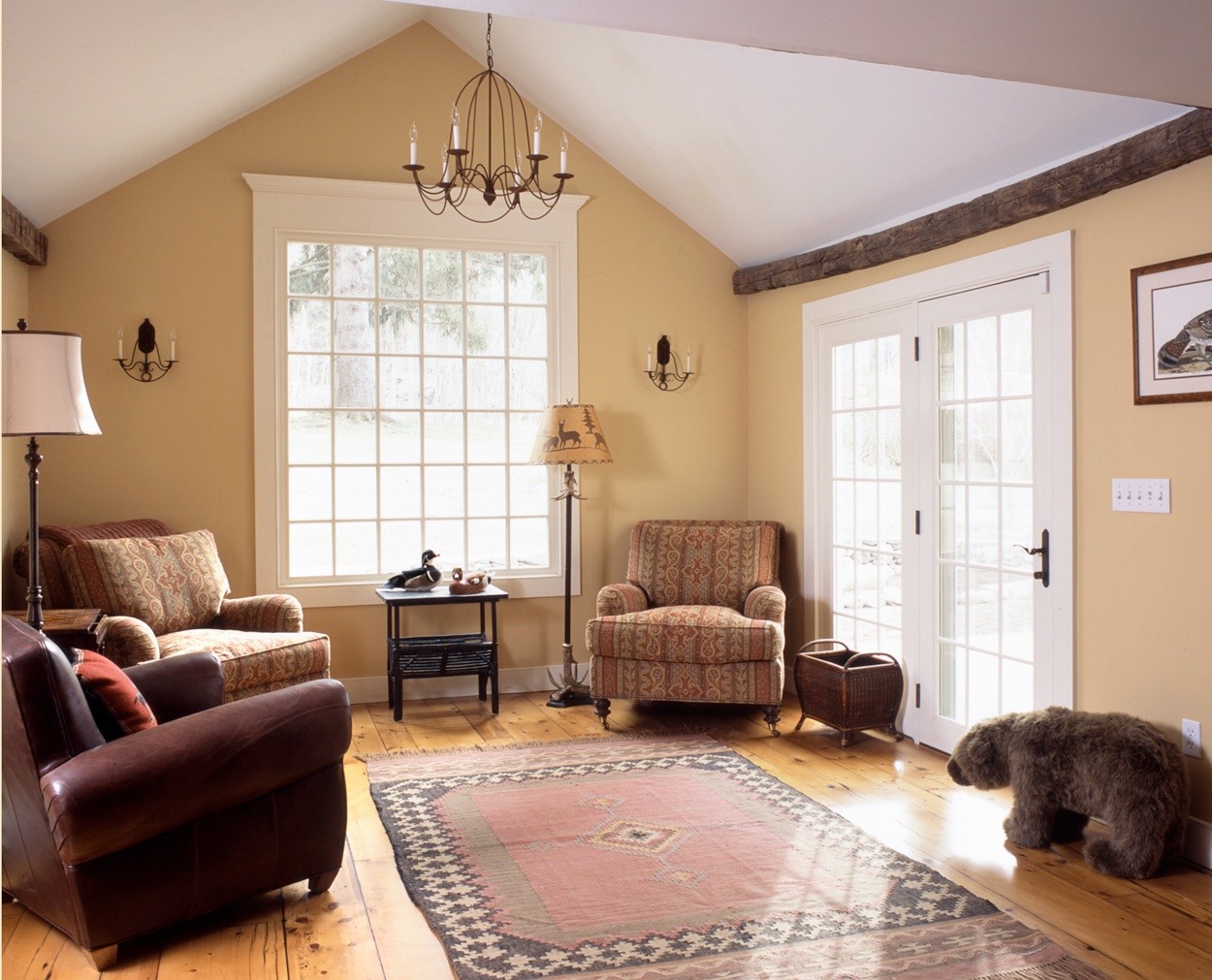 Stuffed bear in great room with large picture window and vintage beams.