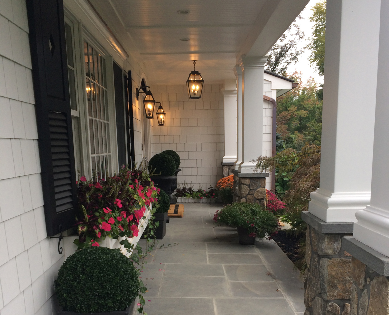 Front porch features beadboard ceiling and columns with stone bases.