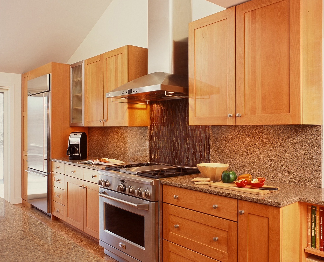 Lightly stained birch cabinets highlight this range wall in a remodeled kitchen.