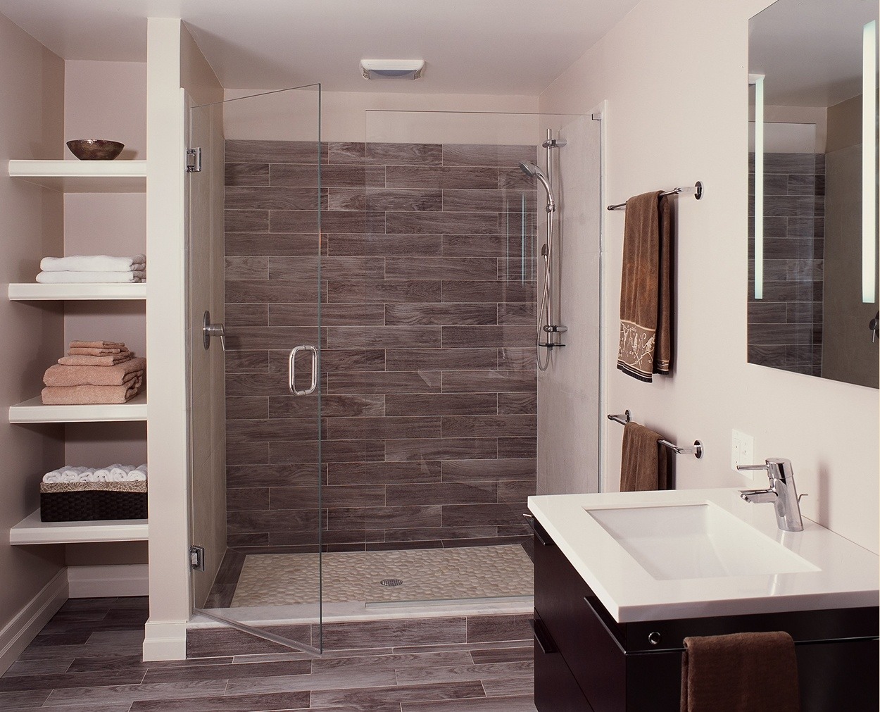 Modern bath with free standing vanity in a dark wood.